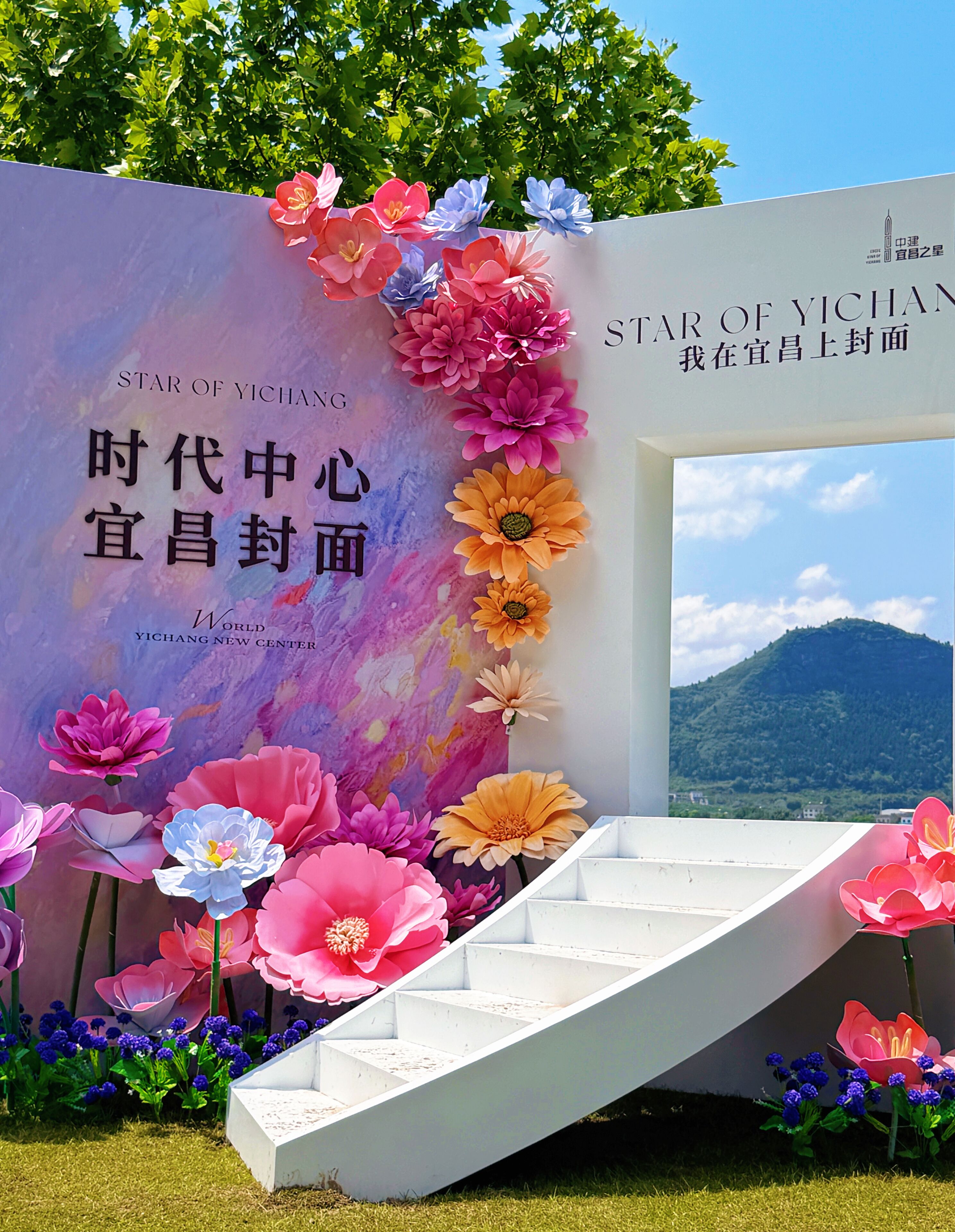 A staircase leading up to a wall with a sign that reads 'Star of Yichang' and 'World Yichang New Center.'