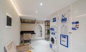 Ein modernes Interieur mit einer Sitzecke, einer Waschmaschine und Informationspostern.