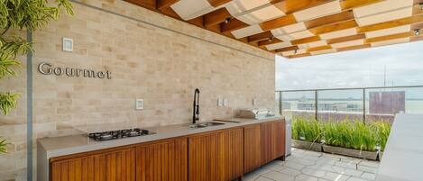 A modern kitchen with a wooden countertop, a gas stove, and a backsplash of beige tiles.