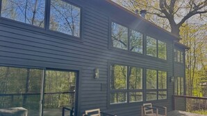 A modern house with large windows and a wooden deck. - Beach Park Estate: Chef's Kitchen, Nature, Fitness Room, Naval Base, Beach, Lake (Beach Park)