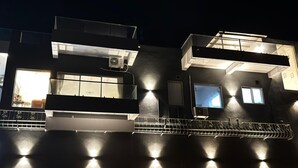 A modern building with multiple windows and a balcony. - Casa Oceanus - 3 Bedroom - Sea Facing Pool Villa - Ganpatipule - Ratnagiri (Ganpatipule - Ratnagiri)