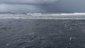 A beach with dark sand and rough waves under a cloudy sky. - Casa Oceanus - 3 Bedroom - Sea Facing Pool Villa - Ganpatipule - Ratnagiri (Ganpatipule - Ratnagiri)