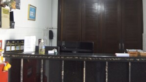 A kitchen with a black countertop, wooden cabinets, and a ceiling fan. - Hotel Cuca Fresca (Cotia)