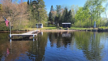 Un lac paisible avec un quai, un petit pavillon et un kiosque.