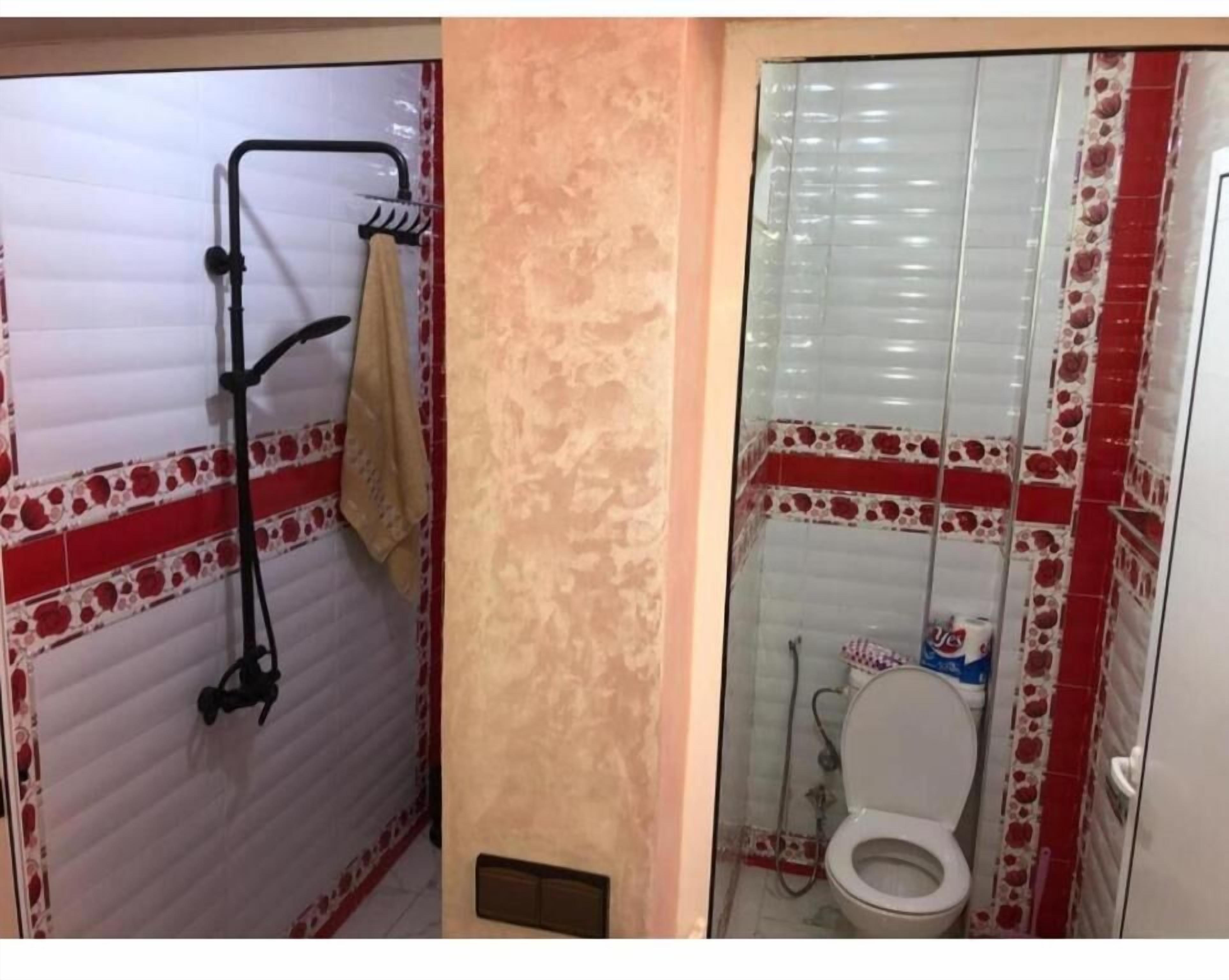 Un baño con ducha, inodoro y toallero.