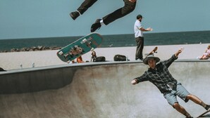 Un parc à skate avec une rampe en béton et une plage en arrière-plan.