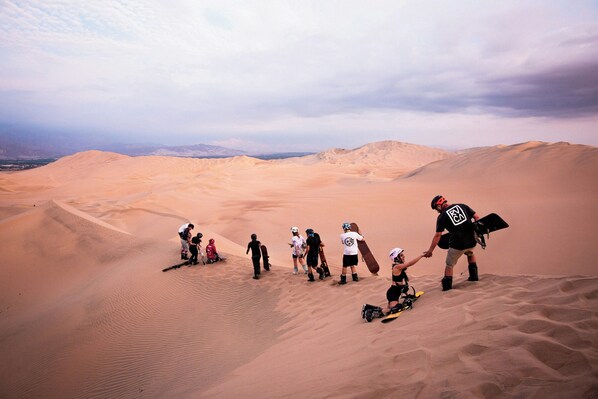 A group of people in a desert landscape with sand dunes.