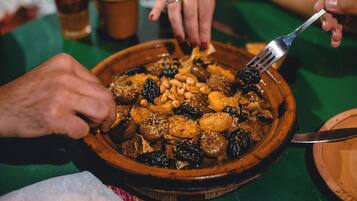Primer pla d'un plat amb diferents fruits secs i olis en un bol de fusta.