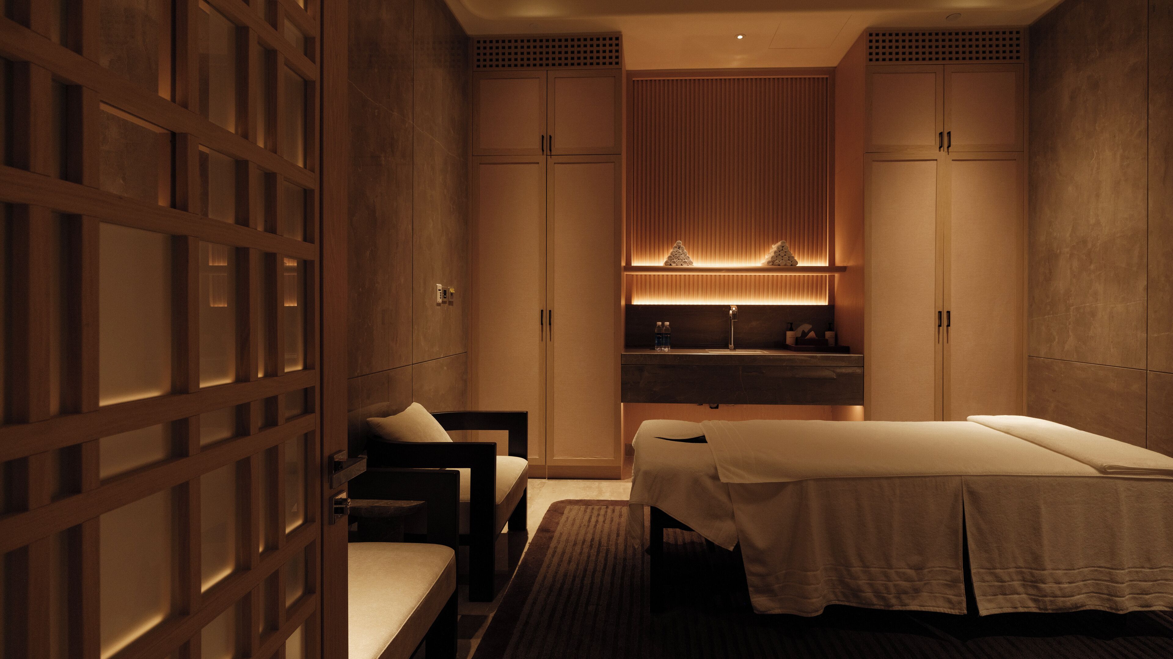 A hotel room with a bed, a desk, and a seating area.