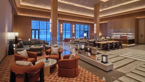 A spacious lobby with a checkered floor, multiple seating areas, and a reception desk. - Hilton Altay Hemu (Burqin)
