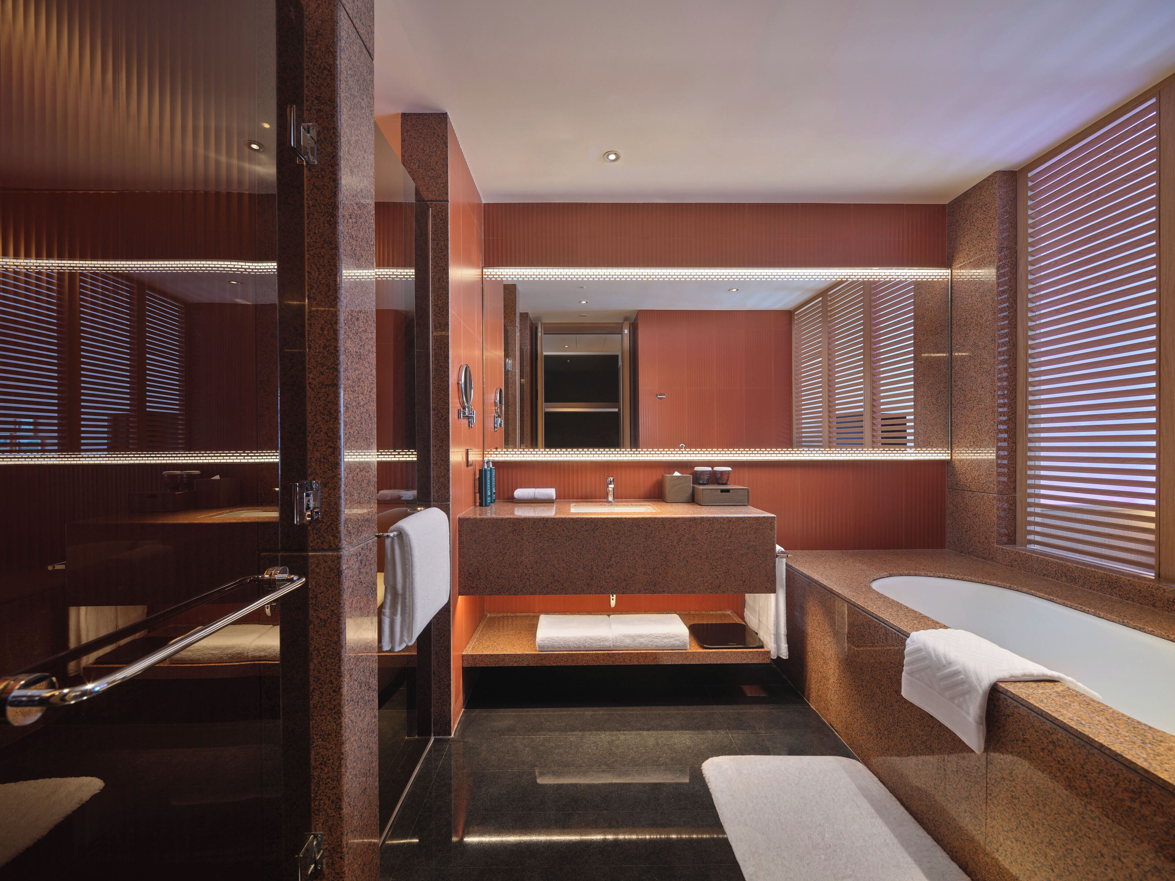 Een moderne badkamer met een grote spiegel, een wastafel en een bad.