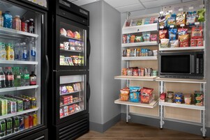 Un espacio autoservicio con bebidas refrigeradas, aperitivos y microondas.