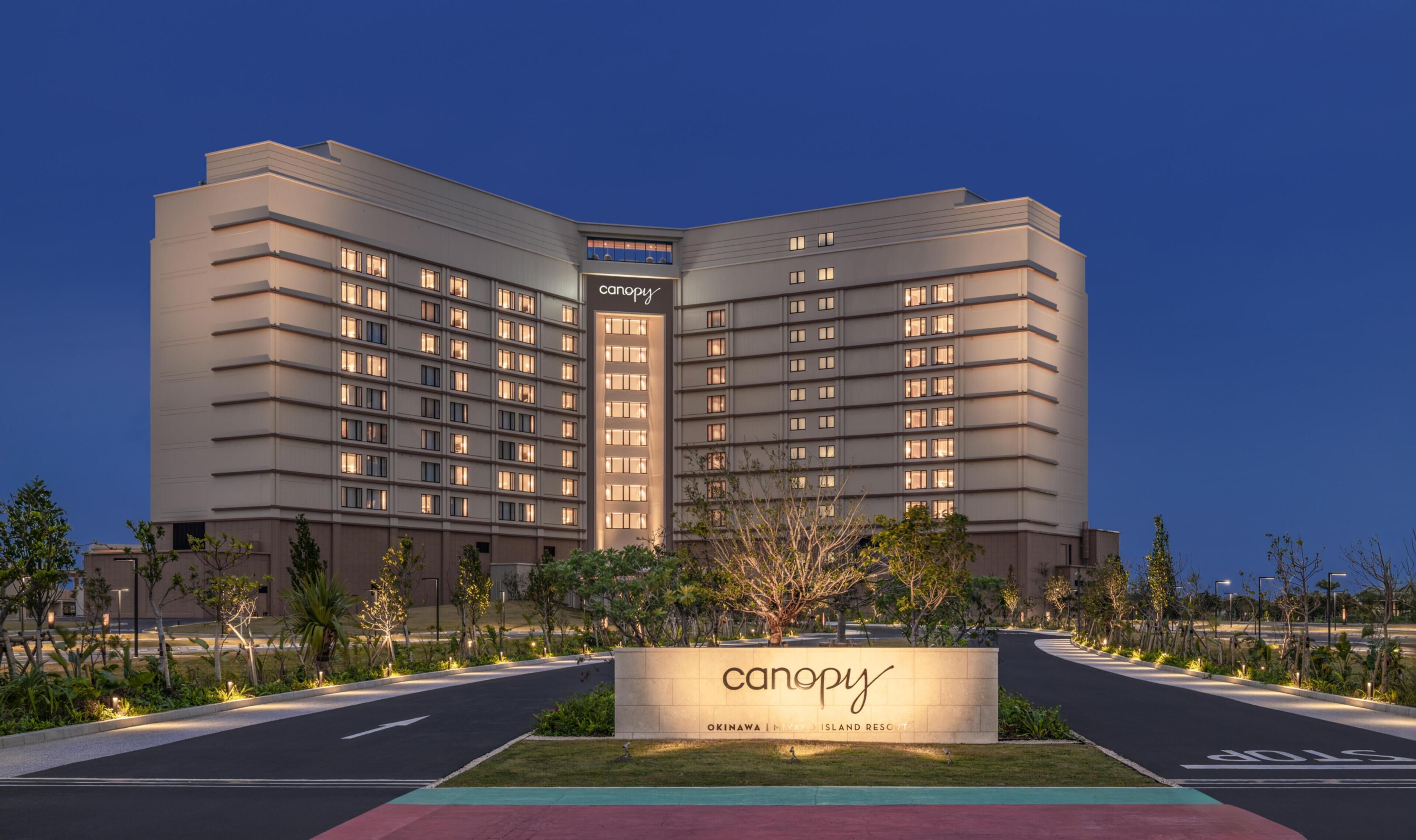 A modern hotel with a prominent 'canopy' sign, featuring a multi-story structure with evenly spaced windows and a flat roof.