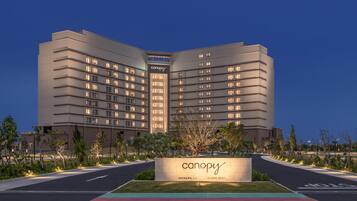 A modern hotel with a prominent 'canopy' sign, featuring a multi-story structure with evenly spaced windows and a flat roof.