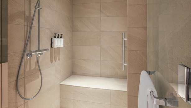 A modern bathroom with a shower, a toilet, and a sink. - Canopy By Hilton Okinawa Miyako Island Resort (Miyakojima)