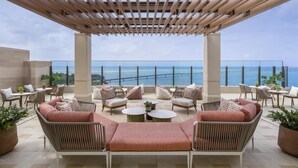 A covered outdoor seating area with a view of the sea. - Canopy By Hilton Okinawa Miyako Island Resort (Miyakojima)