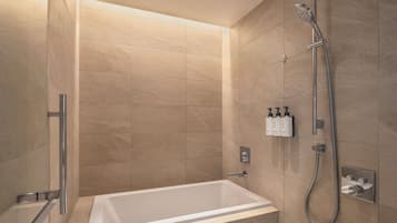 A modern bathroom with a bathtub, shower, and hand sanitizer dispensers.