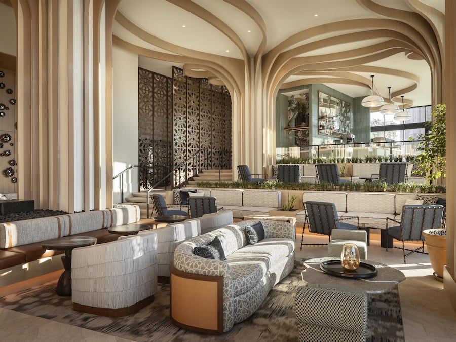 Ein geräumiger Lounge-Bereich mit verschiedenen Sitzgelegenheiten, darunter Sofas und Sessel, die um einen zentralen Couchtisch angeordnet sind.