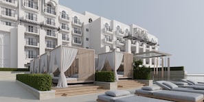 Un hôtel moderne doté d’une piscine sur le toit, avec des chaises longues et un espace salon couvert agrémenté de rideaux.