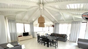 Un amplio salón con una mesa de comedor, sofás y una televisión.