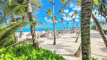 Am Strand, weißer Sandstrand, Liegestühle, Sonnenschirme