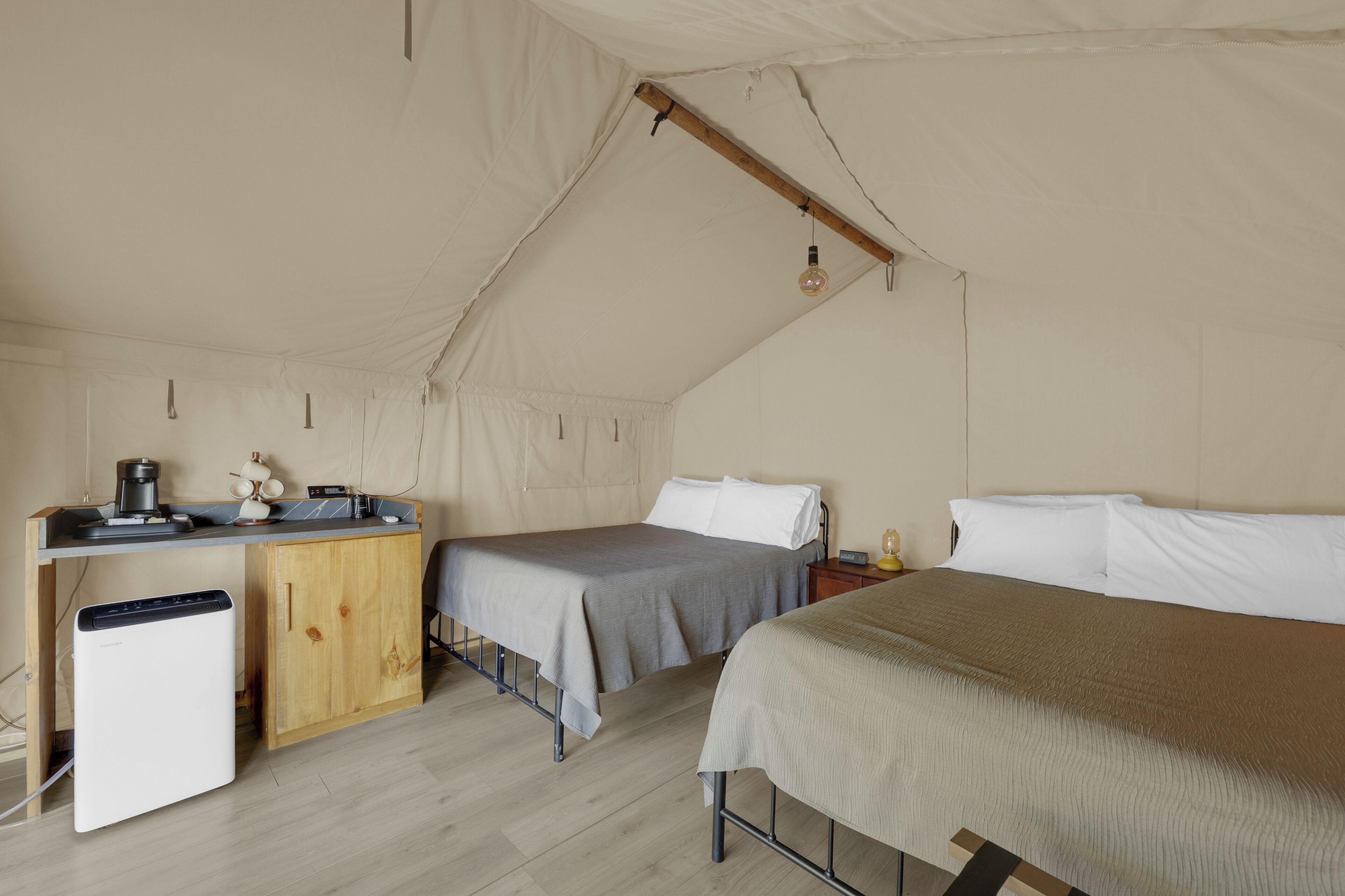 Alojamiento con carpa que incluye dos camas, una kitchenette pequeña y un baño compacto.