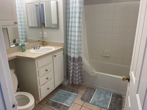 Un baño con inodoro, lavamanos, espejo y ducha.