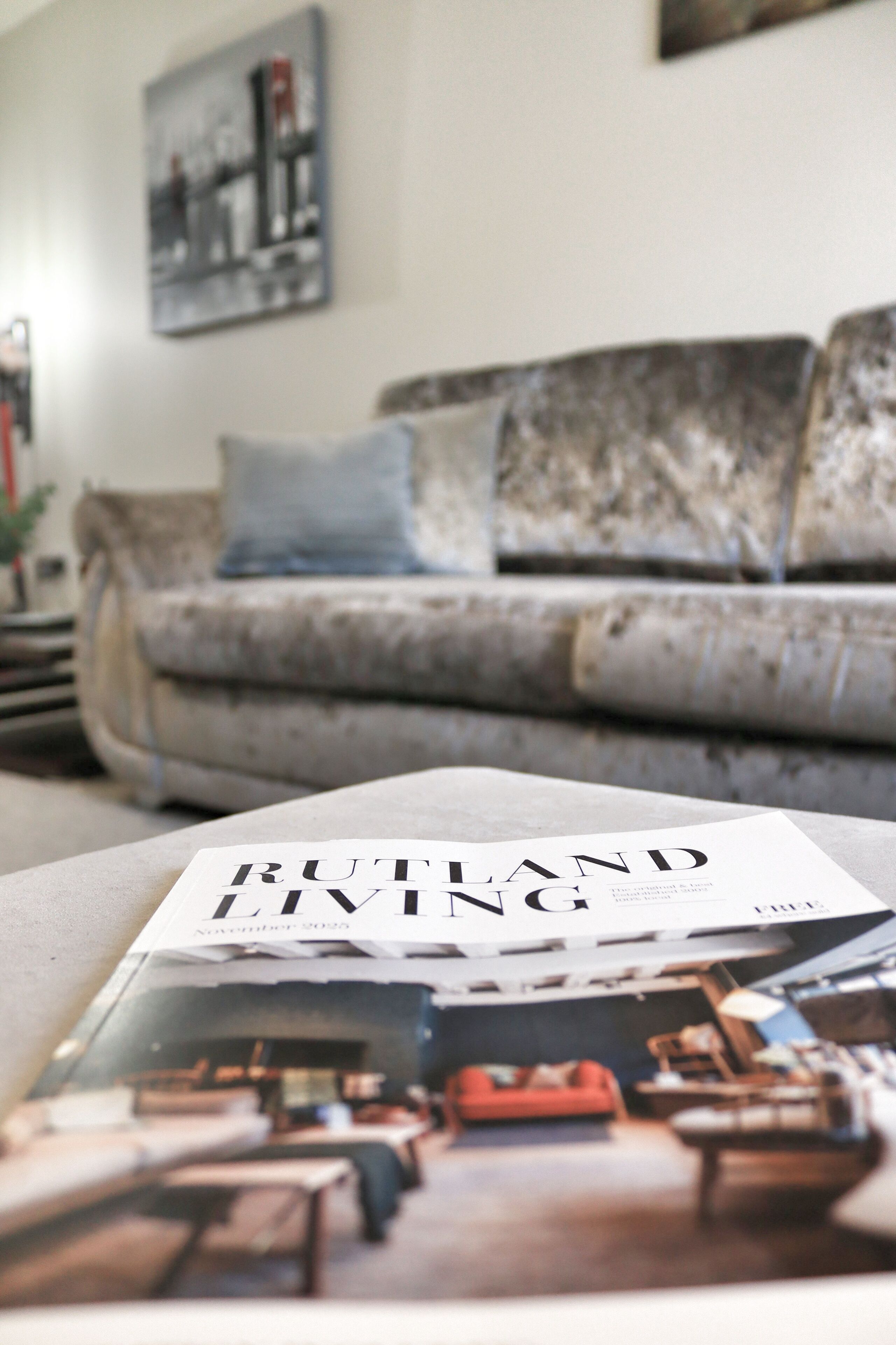 Un magazine posé sur un canapé, avec un arrière-plan flou représentant un salon.