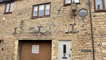 Ein Steinhaus mit geschlossenem Garagentor, einer Straßenlaterne und einem Schild, das ein Parkverbot anzeigt.