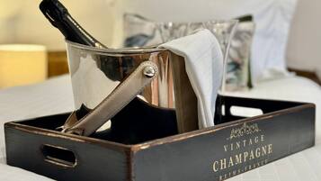 Een champagnefles uit een oudere jaargang in een metalen emmer met handvat, geplaatst op een houten dienblad met de tekst