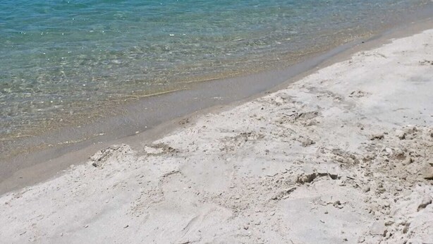 A beach with clear turquoise water and white sand.