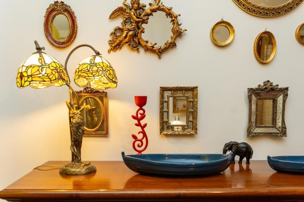 A table with a lamp, decorative plates, and a small elephant figurine.