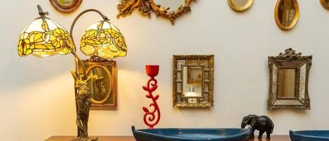 A table with a lamp, decorative plates, and a small elephant figurine.