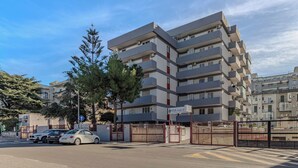 A multi-story residential building with balconies, a gated entrance, and parked cars. - Andrea's home Bari (Bari)