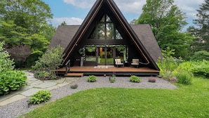 A modern A-frame house with a wooden deck, large windows, and a well-maintained garden. - Rustic A Frame Cabin. Nature retreat on 4 acres! 15 minutes from 3 waterfalls (LaFayette)
