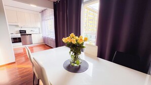 A modern kitchen with white cabinets, a built-in oven, and a microwave.