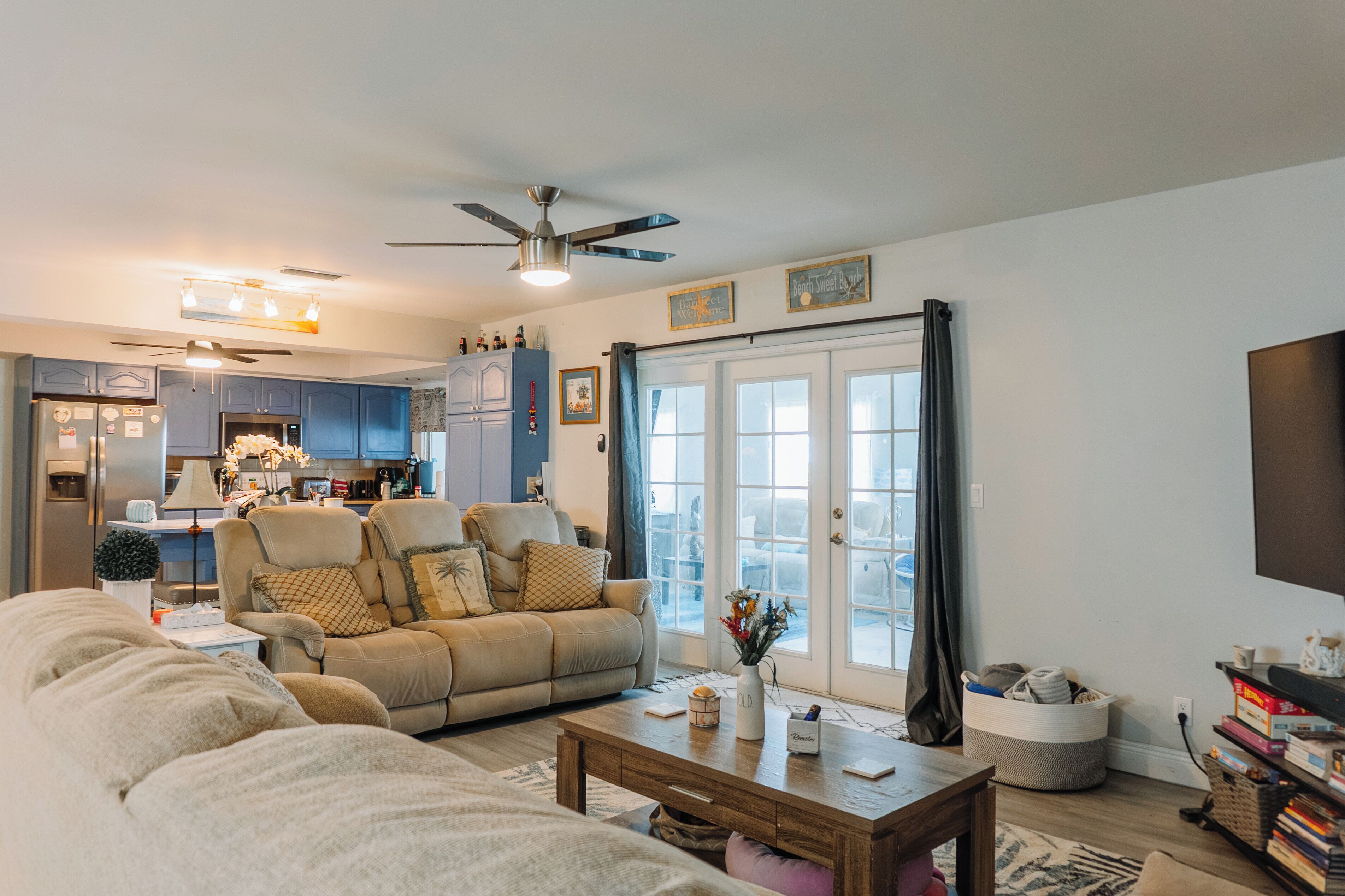 A modern living room with a sofa, coffee table, and a view of the kitchen.