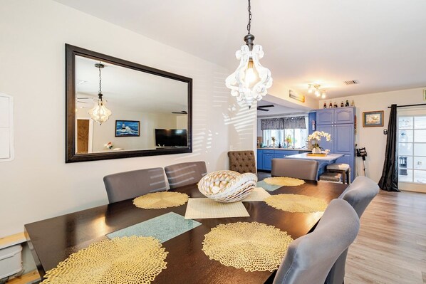 A dining area with a dark wooden table, multiple chairs, and a large mirror on the wall.