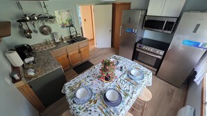 A compact kitchen with a central island, a refrigerator, a microwave, and a stove.