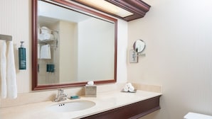 A bathroom with a large mirror, a sink, a toilet, and a towel rack. - The Marc Hotel (Milwaukee)