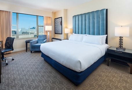 In-room safe, desk, laptop workspace, blackout curtains. The Marc Hotel