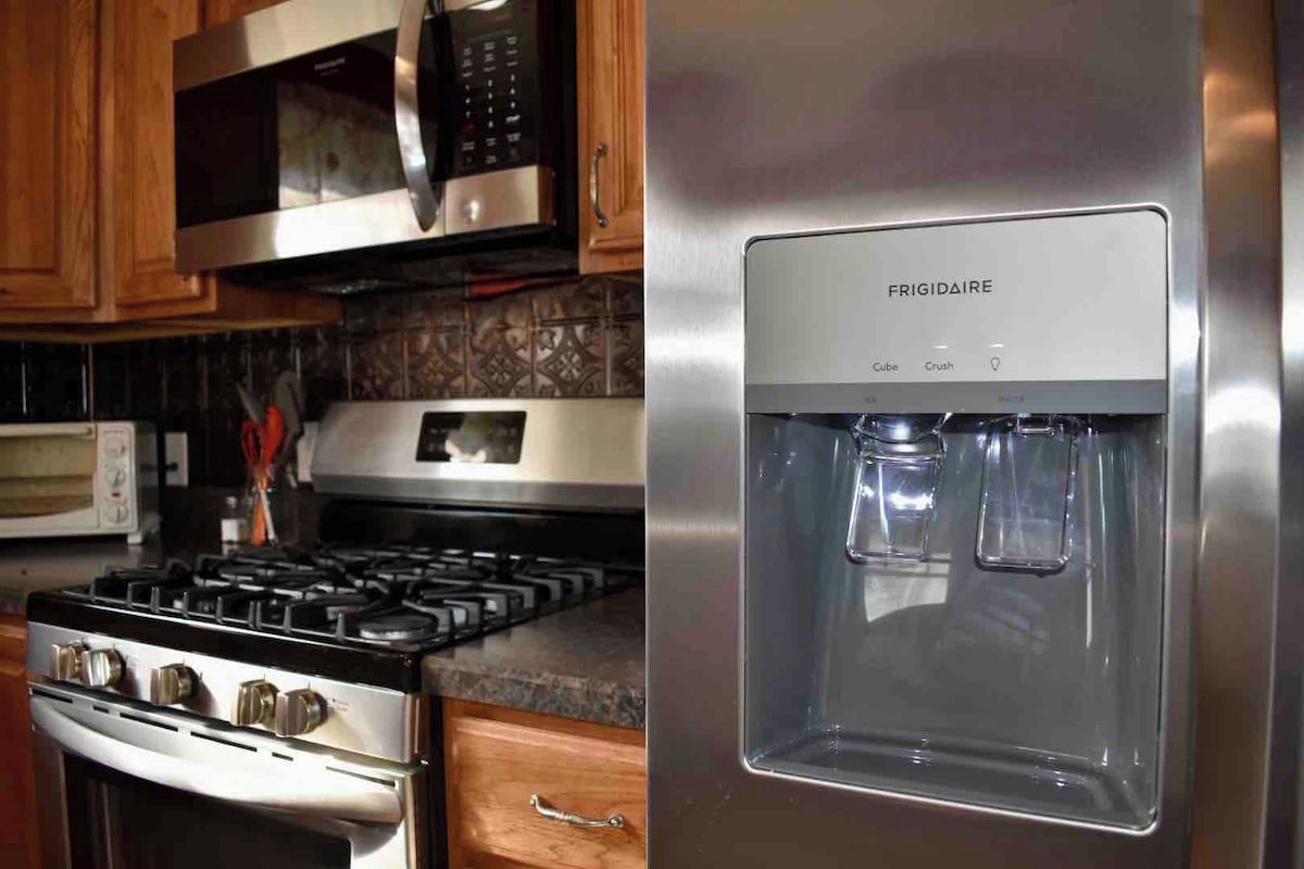 A kitchen with a stainless steel stove, a microwave, and a water dispenser.