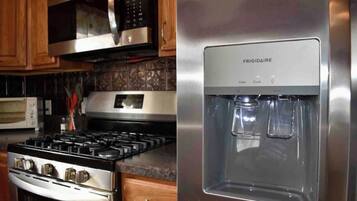 A kitchen with a stainless steel stove, a microwave, and a water dispenser.