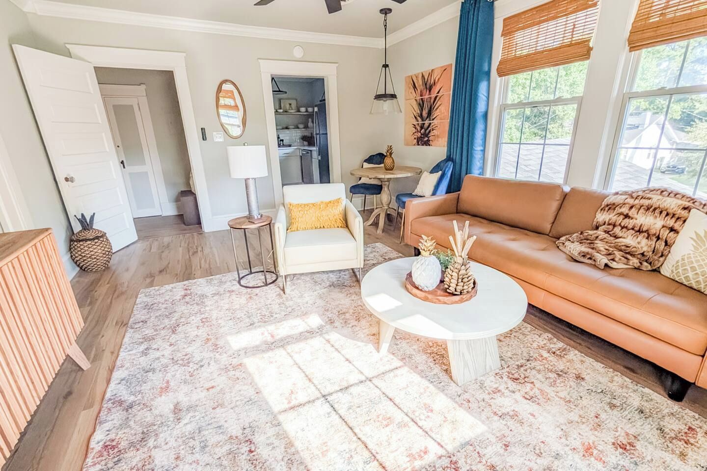A living room with a sofa, coffee table, and a dining area with a table and chairs.