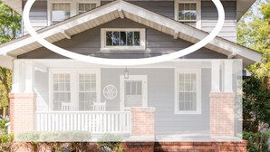 A two-story house with a front porch, a chimney, and a small window on the upper floor. - Charming Private 2nd Floor Suite Downtown (Florence)