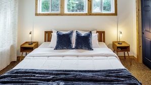 A bedroom with a large bed, two bedside tables, and three windows. - Private Cabin Villege with Hot Tubs & Firepit for 16 people (Cherokee County)