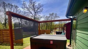 A hot tub with steps, a wooden deck, and a covered seating area. - Private Cabin Villege with Hot Tubs & Firepit for 16 people (Cherokee County)