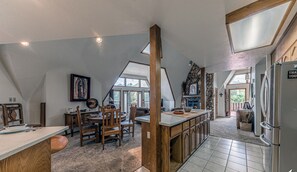 A spacious kitchen with a central island, wooden cabinets, and a stone accent wall.