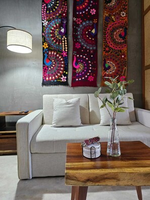 Ein modernes Wohnzimmer mit einer Couch, einem Holztisch und einer Pflanze in einer Vase.