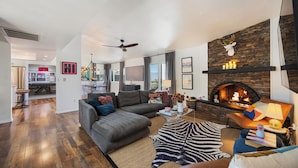 A modern living room with a fireplace, a sectional sofa, a coffee table, and a zebra print rug.